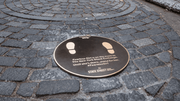 Fearless Girl plaque: 'Fearless Girl is on the move to The New York Stock Exchange. Until she's there, stand for her. #FearlessGirl'