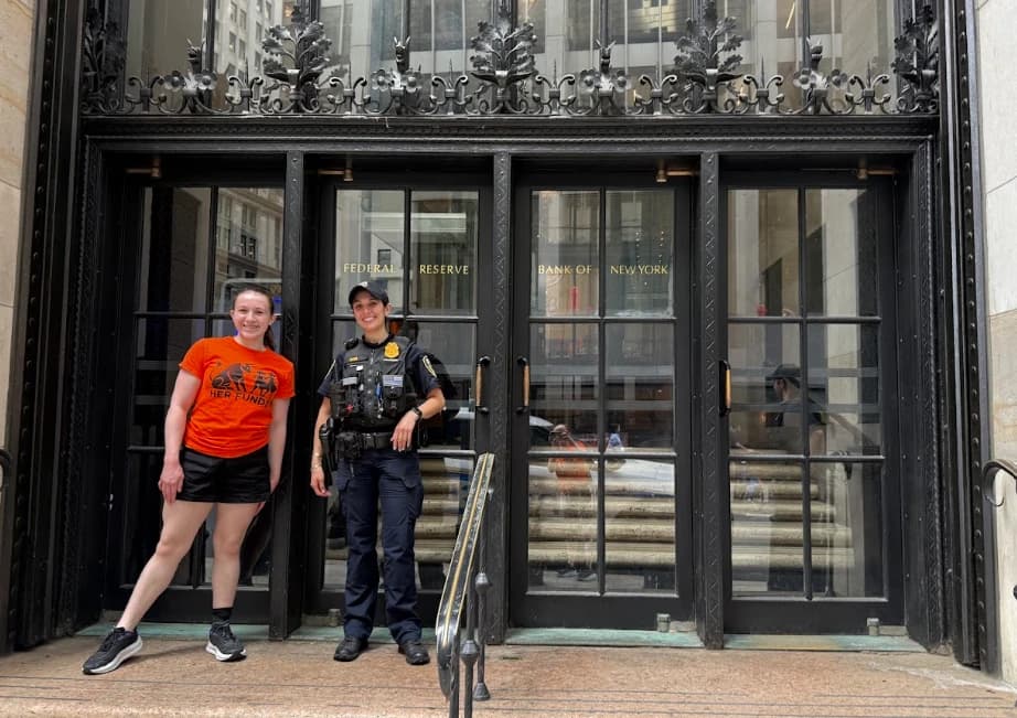Sophia DeGregorio in a Her Funds t-shirt with a Federal Reserve Bank of New York police officer