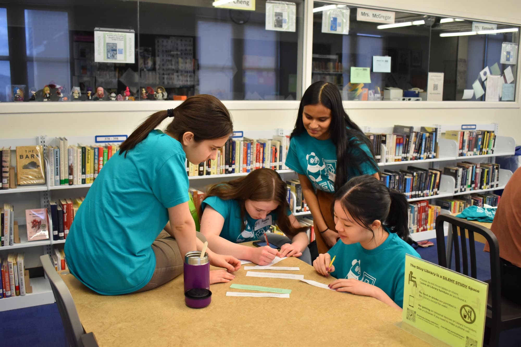 GEMS team members writing problems together at a table in the library