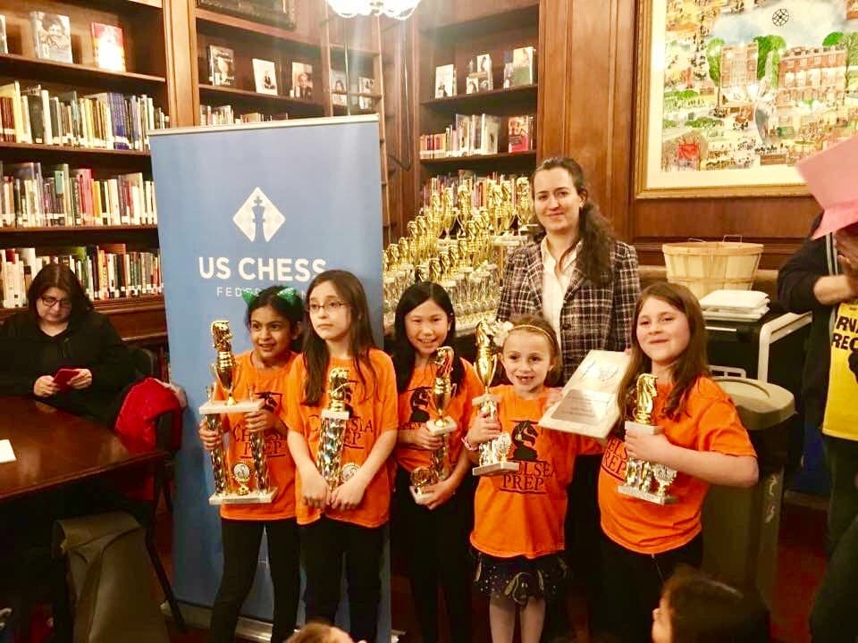 Sophia's all-girls chess team posing with trophies alongside Grandmaster Irina Krush