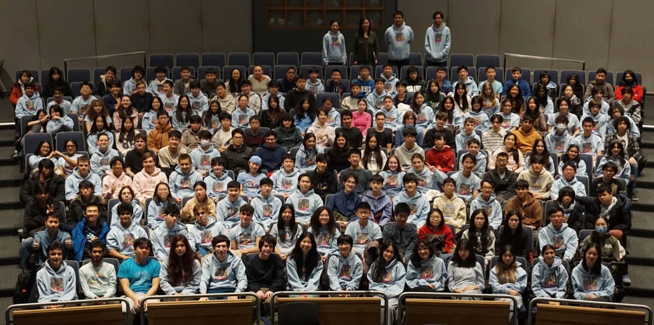 The full Stuyvesant Math Team posing together in an auditorium